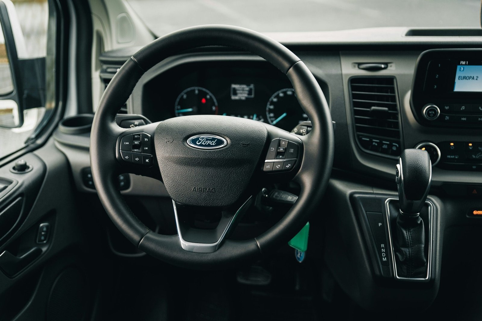 the interior of a car with a steering wheel and dashboard